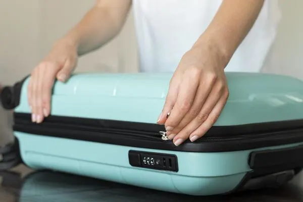 a woman is packing with a lightweight carry-on