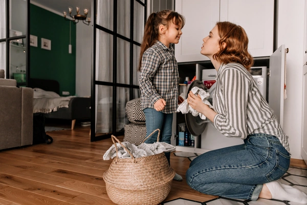 beautiful-woman-sits-floor-wipes-lid-off-pan-while-her-little-daughter-speaks-her-ezgif.com-jpg-to-webp-converter